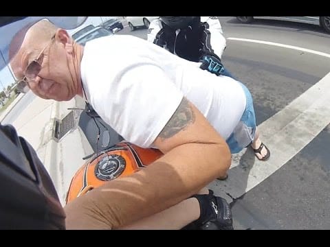 Stirnkamera filmt wie ein wutentbrannter Autofahrer einen Motorradfahrer attackiert. Der Grund für den Ausraster ist lächerlich!